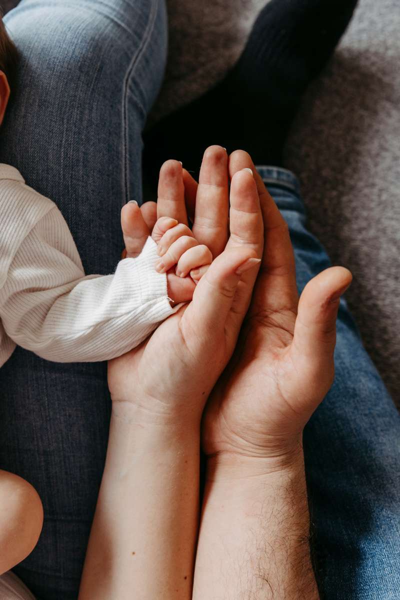 Babyhand liegt in den H&auml;nden der Eltern